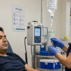 Paciente recibe tratamiento intravenoso en un centro especializado, mientras especialista advierte sobre el diagnóstico tardío de la Mucopolisacaridosis.