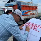 Una autoridad firma un sello que pusieron a una piladora que fue clausurada.