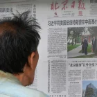 Un hombre lee un periódico en Pekín sobre la visita de Donald Trump a Xi Jinping.