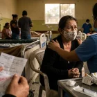 Una paciente recibe consuelo en un sistema de salud que lucha contra el desabastecimiento.
