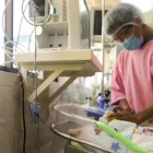 Un integrante del personal hospitalario da de comer a un bebé conectado a una cánula de oxígeno el 21 de mayo de 2026, en un hospital en La Paz (Bolivia).