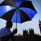 Un hombre se protege del sol con un paraguas en Londres.