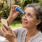 Un usuario aplica gotas VIZZ, el tratamiento que busca reemplazar los lentes de lectura.