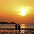 Personas pasean por una playa West Kirkby (Reino Unido). en una jornada calurosa.