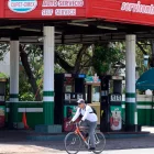 Una persona pasando en bicicleta frente a una estación de gasolina cerrada en La Habana (Cuba).