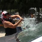 Una persona vandaliza un vehículo este martes, durante una protesta de integrantes de la Coordinadora Nacional de Trabajadores de la Educación (CNTE), en Chilpancingo (México).
