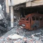 Entre los escombros del centro comercial Multicomercio hay carrocerías de vehículos.