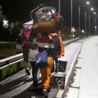 Inmigrantes cargando sus pertenencias caminan por una calle de Stanford, a unos 120 kilómetros de Ciudad del Cabo.