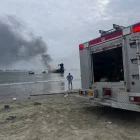 Bomberos trabajan para controlar los focos reactivados del incendio en el puerto de Manta, una de las emergencias más graves para el sector pesquero.