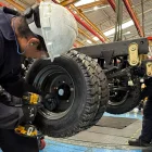 Un par de trabajadores cumplen su jornada en una fábrica de carros.