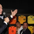 El presidente de la FIFA, Gianni Infantino, se dirige al público durante un evento oficial rodeado de camisetas históricas de selecciones nacionales.