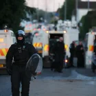 Un agente de policía camina con equipo antidisturbios en el lugar de los disturbios antiinmigración en Antrim Road en Newtownabbey, al norte de Belfast, Irlanda del Norte.