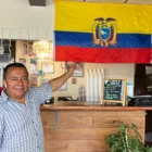 Segundo López posa con orgullo junto a la bandera tricolor que adorna su restaurante, "El Sazón de Doña Eva", en Upper Darby.