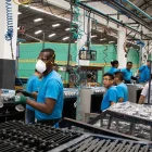 Un grupo de trabajadores cumple con su jornada laboral en una fábrica.