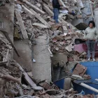 Residentes caminan entre los escombros de edificios derrumbados tras los terremotos en Catia La Mar, estado La Guaira.
