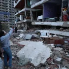 Residentes entre los escombros de uno de los bloques de viviendas dañados por los terremotos, en el estado costero de La Guaira (Venezuela) este jueves.