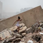 Personas caminan entre los escombros de edificios colapsados tras los terremotos en La Guaira, Venezuela.