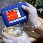 Una persona inspeccionando mercancía durante un operativo en el que decomisaron 30 kilos de presunta cocaína ocultos en piñas en Santo Domingo (República Dominicana).