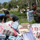 Personas descargan ayudas humanitarias este lunes en La Guaira, Venezuela, tras los sismos.