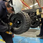 Un par de trabajadores cumplen su jornada laboral en una fábrica de carros.
