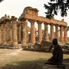 Un hombre se sienta a la sombra frente al Templo de Zeus en el sitio arqueológico de Cirene,en la costa mediterránea nororiental de Libia, el 18 de mayo de 2026.