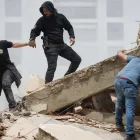 Personas caminan entre los escombros de edificios derrumbados en La Guaira tras los terremotos en Venezuela.