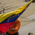 Un integrante de Protección Civil coloca la bandera de Venezuela en La Guaira tras los terremotos