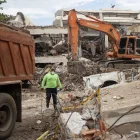 Una persona camina entre máquinas y escombros de edificios colapsados este lunes, en La Guaira (Venezuela).