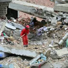 Un trabajador remueve escombros de un edificio colapsado en La Guaira.