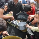 Adultos y niños buscan algo de alimenación.