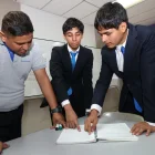 Sebastián Yépez (centro) y Leonel Vargas, del colegio Interamericano, reciben la guía del docente Jhonny Solórzano.