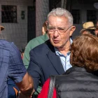 El expresidente (2002-2010), Álvaro Uribe, saluda a un simpatizante a su llegada a un colegio electoral para votar durante la segunda vuelta de las elecciones presidenciales del 21 de junio de 2026.
