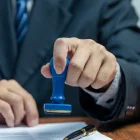 Referencial.Un funcionario estampa la autorización en un documento, requisito indispensable para la salida de menores en Ecuador.