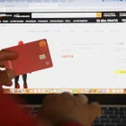 Una persona hace compras en línea usando su tarjeta bancaria.