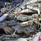 Un integrante de organismos de socorro camina sobre los escombros de una edificación destruida tras el terremoto de magnitud 7,4 que sacudió la víspera la mayor parte de Colombia, este martes en Pereira (Colombia).
