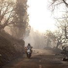 Un hombre pasa cerca de coches quemados tras un incendio forestal cerca de la ciudad de Omis, Croacia, el 14 de agosto de 2026.