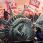 Una mujer iraní camina junto a un cartel antiestadounidense en la plaza Enghelab en el centro de Teherán, Irán, el 13 de agosto de 2026.
