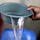 El hondureño Darwin Ordoñez llena un recipiente con agua este 14 de agosto de 2026, en Tegucigalpa (Honduras).