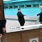 Una mujer pasa junto a una pantalla de televisión que muestra reunión entre el presidente Donald Trump y el líder norcoreano Kim Jong Un, en estación de tren de Seúl.