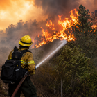 Bombero combate un incendio forestal mientras las llamas avanzan entre la vegetación.