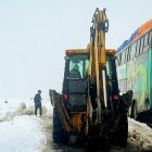 Operarios trabajando con maquinaria amarilla para limpiar una carretera durante una nevada en La Paz (Bolivia).