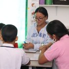 Una maestra junto a jóvenes en un centro de apoyo terapéutico.