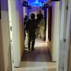 Agentes policiales inspeccionan el interior del night club en Cuenca, donde se halló una caleta con dinero oculto.
