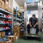 Taichi Konishi, empleado de Konoe, descansa en una cabina de refrigeración para trabajadores, también conocida como "nevera humana", en el almacén de la empresa, en un día caluroso en Higashiosaka, prefectura de Osaka.