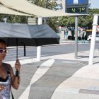 Una mujer se protege con un paraguas del intenso sol el 19 de agosto de 2026 en la plaza América de Valencia.