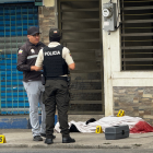 Agentes policiales resguardan la escena del crimen donde fue asesinado un bombero en Machala.