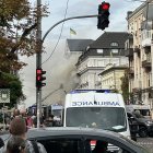 Personas observan cómo rescatistas trabajan para extinguir un incendio tras un ataque aéreo en Kiev.