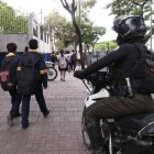 Agente policial custodia el ingreso de estudiantes a un colegio en el norte de Guayaquil.