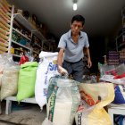 Un comerciante muestra que el arroz de grano largo es de mejor calidad y que la libra cuesta 0,50 dólares.