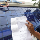 Una persona presenta su planilla de luz en CNEL.